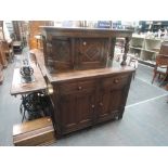 A mid 20th century oak court cupboard in the Jacobean style having carved decoration with canted and