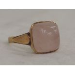A lady's dress ring having a square pink agate cabouchon stone in a collared mount to shaped