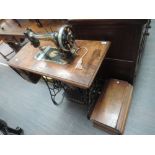 An early 20th Singer sewing machine in mahogany and stained frame case on treadle base