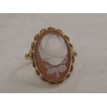 A lady's dress ring having an oval conche shell cameo depicting a rose bud, in a collared mount with
