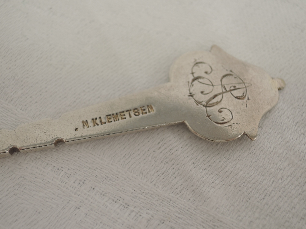A pair of white metal spoons, possibly Danish having bright cut engraving to decorative terminals - Image 2 of 2