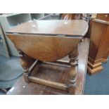 A mid/late 20th century oak coffee table having drop leaf swivel top on turned legs