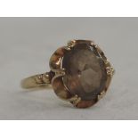 A lady's dress ring having an oval smoky topaz in a decorative frilled mount on a 9ct gold loop