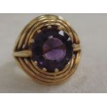 A lady's dress ring having an amethyst stone in a claw setting in a stylised wire mount on a