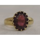A Victorian lady's dress ring having an oval garnet in a claw mount on an 18ct gold loop