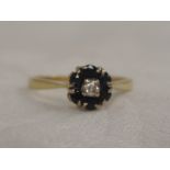 A ladies dress ring having a diamond and sapphire cluster on a yellow metal loop, marks worn