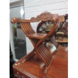 A modern hardwood savanorola armchair having crest, lion mask arms and slatted frame