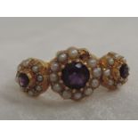 A lady's dress ring having three graduated amethyst and seed pearl clusters to moulded shoulders
