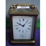 An early 20th century brass carriage clock of traditional design with handle