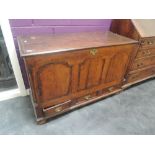 An 18th century oak mule chest having fielded panels and half pillars with drawers under, on later