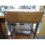 An early 20th century golden oak occasional table having drop leaf top with gallery undertier and