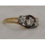 A lady's dress ring having three graduated diamonds in claw set illusionary mount to cross over