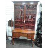 An early 20th century mahogany bookcase/display cabinet having astral glaze top over frieze, slide