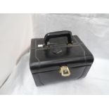A black leather rectangular vanity case of rigid form having fleur de lis decorated lining,