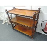 A Victorian mahogany buffet having three tiers and turned pillar supports with central drawers