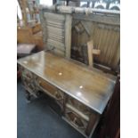 An early/mid 20th century oak bedroom suite in the Jacobean style with foliate and linen carved