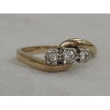 A lady's dress ring having three diamonds in an illusionary setting to cross over shoulders on a 9ct