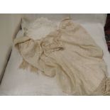 An early 20th century cream silk shawl having embroidered scroll and floral decoration and tassel