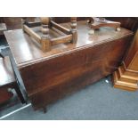 An early 19th century oak dining table having rectangular drop leaf top on square gate legs