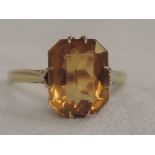 A lady's dress ring having a citrine stone to collared mount on a yellow metal loop stamped 9ct