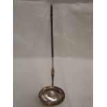 A Georgian white metal toddy spoon having coin insert dated 1787 with a twisted whale bone handle,