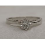 A lady's diamond solitaire ring, approx .25ct in a claw setting to open shoulders on a rhodium