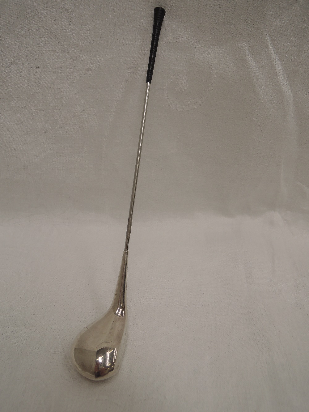 A white metal trophy modelled as a weighted golf club by Frigast Denmark, engraved GC 1975