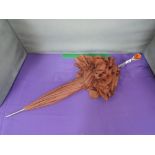 A vintage parasol having white metal stem with amber style glass inset knop