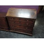 An early 19th century oak bureau having shell inlay decoration, with fall flap and drawer