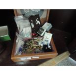 A wooden jewellery box containing a selection of costume jewellery earrings