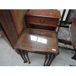 A reproduction yew wood side cabinet and nest of three stained frame period tables