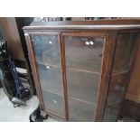 An early/mid 20th century oak display cabinet having canted corners