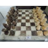 A carved marble chess set with granite board
