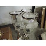 Three plated candlesticks with glass shades