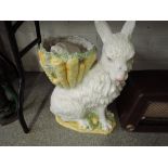 A large ceramic rabbit with bowl on back