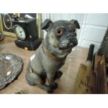 An early 20th century ceramic pug dog figure painted with glassy eyes