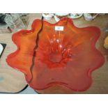 A large ruby red glass bowl in the style of a water splash