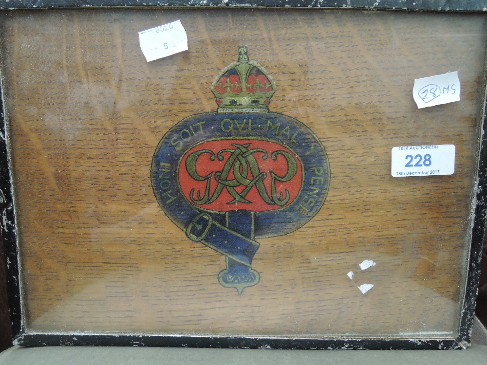 A blue and red Royal Cypher on oak board in metal frame.