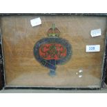 A blue and red Royal Cypher on oak board in metal frame.