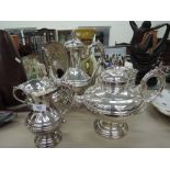 A silver plated four piece tea set having moulded decoration and a plated bottle holder