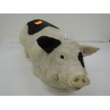 A large piggy bank in the form of a saddleback style pig