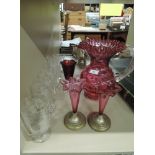 An early 20th century cranberry glass jug, a pair of cranberry glass posy vases, a 19th century ruby