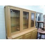 A modern golden oak lounge unit, having glazed display shelves, frieze drawers and triple cupboard