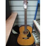 A Yamaha F-310 acoustic guitar, strung left handed, with padded gig bag