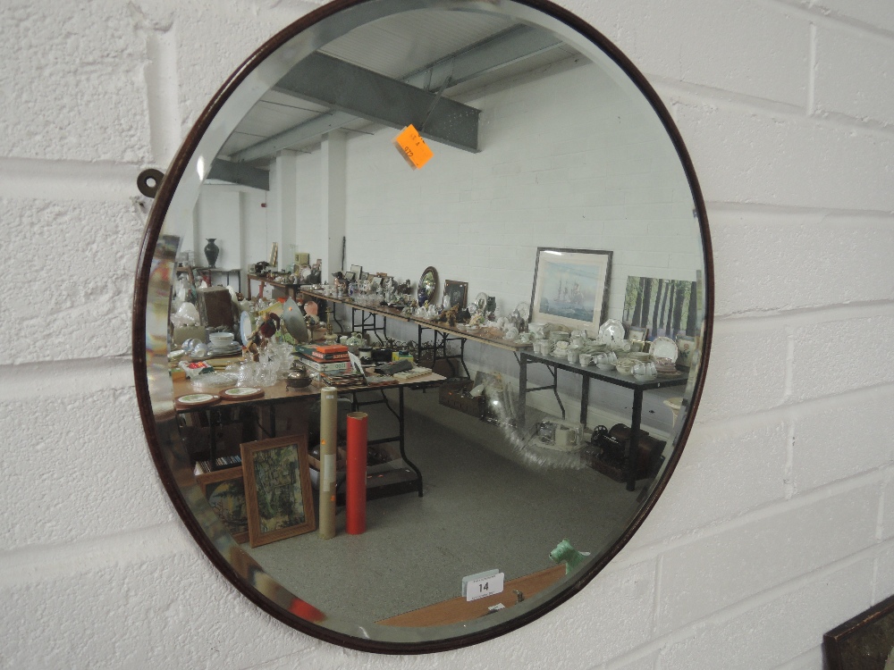 A circular vintage wood framed wall mirror.