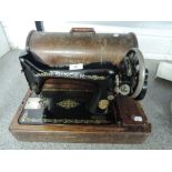 A vintage hand cranked Singer sewing machine serial number F6123067 in wooden case.