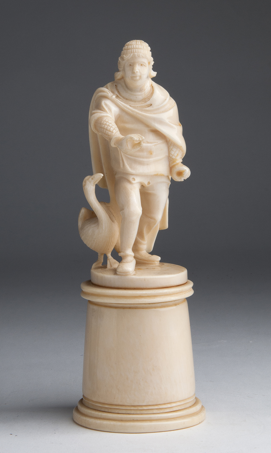 A carved ivory figural group of male figure with a goose - probably France, late 19th / early 20th