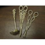 A COLLECTION OF GILT METAL NOVELTY WARE, comprising two grape scissors and a sifting spoon. (3)