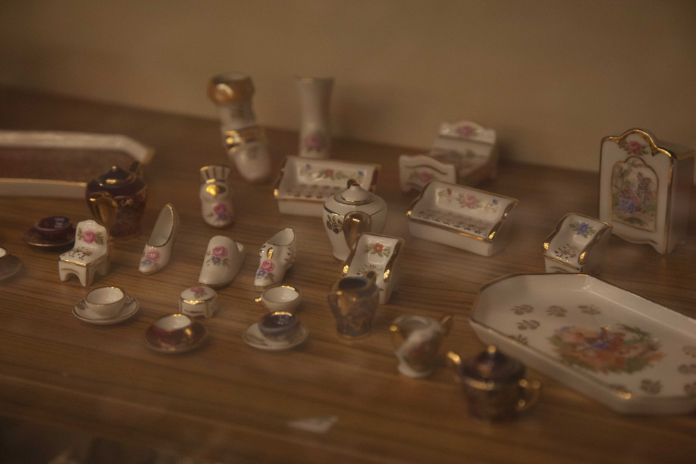 A COLLECTION OF LIMOGES MINIATURE PORCELAINS, comprising various models of doll house furniture, tea