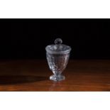 A 19TH CENTURY CUT GLASS URN SHAPED HONEY POT AND COVER, raised on circular lobed moulded foot,